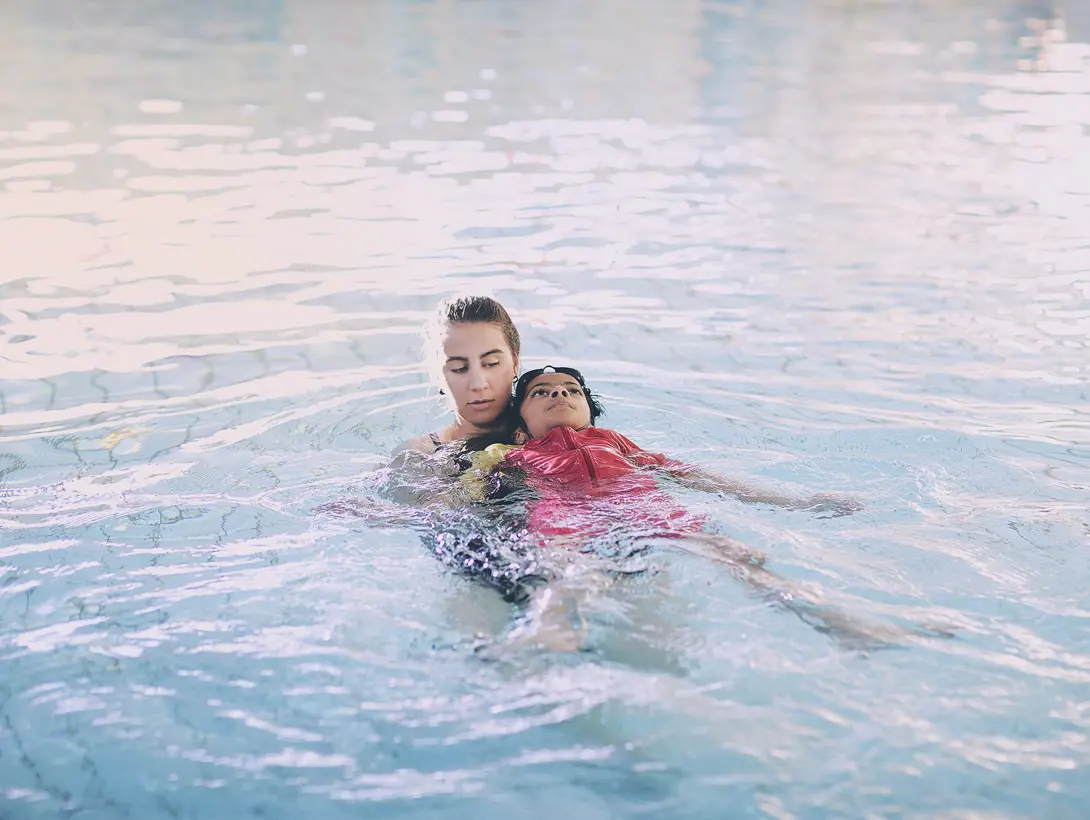 En jente trener ryggsvømming sammen med instruktør. Foto: Christine Stokkebryn