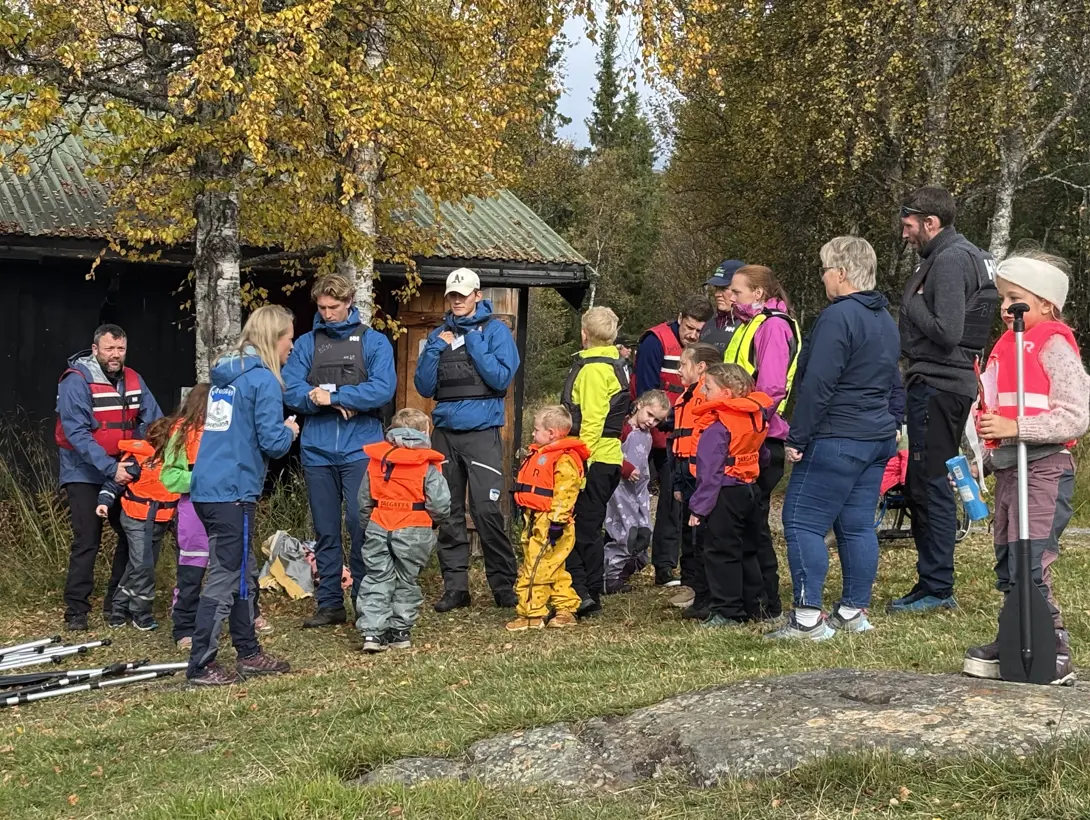 En gruppe barn og voksne gjør seg klare for båtaktivitet