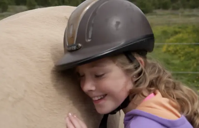Jente koser med hesten
