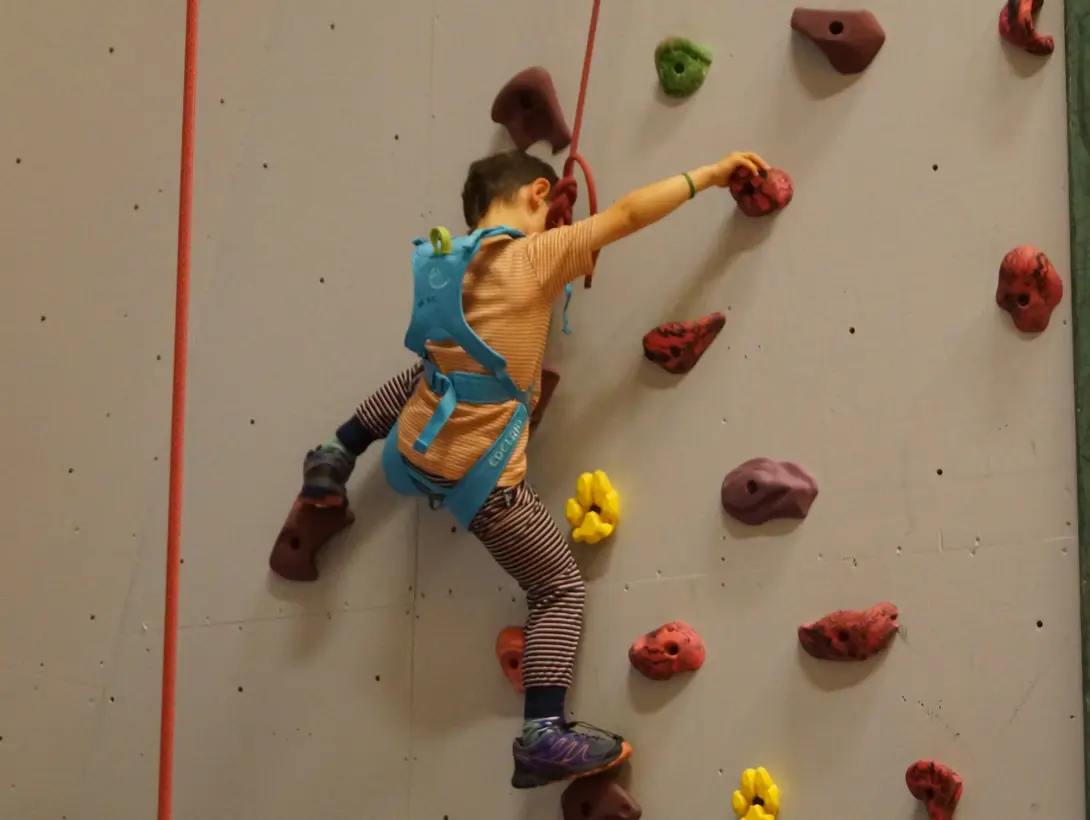 En gutt klatrer i klatreveggen